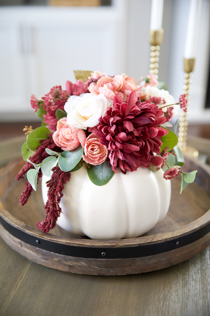 beautiful pink and burgundy flower arrangement in a white pumpkin vase