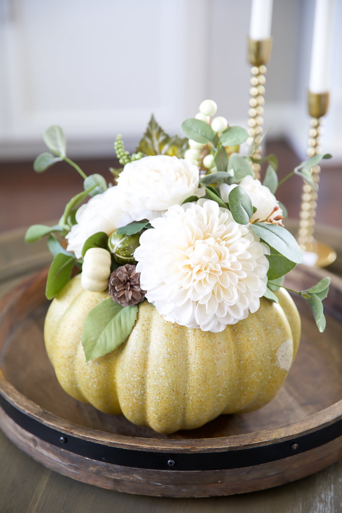 green pumpkin vase with white flower arrangement