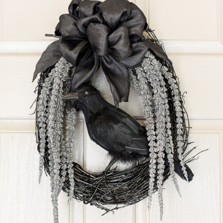 DIY spooky glam Halloween wreath with glittery stems draping down and a black crow to welcome your guests.