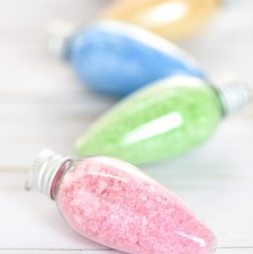 DIY Bath Salts Ornaments – these peppermint scented bath salts in Christmas light ornaments make a great handmade gift idea for under $5!