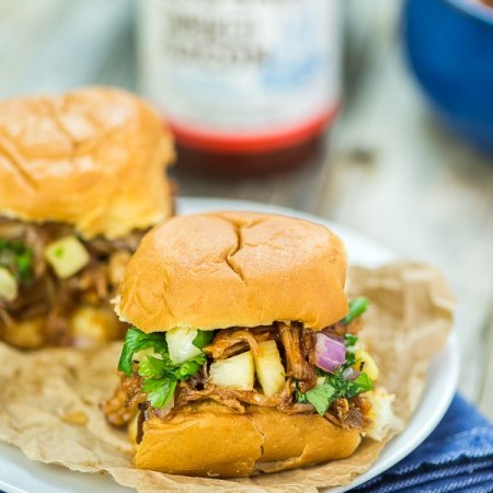 Slow cooker pulled pork sandwiches topped with pineapple salsa.