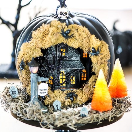 Create a Haunted House Pumpkin Diorama with tiny spooky decorations, complete with a skeleton walkway, candy corn trees and tombstones.