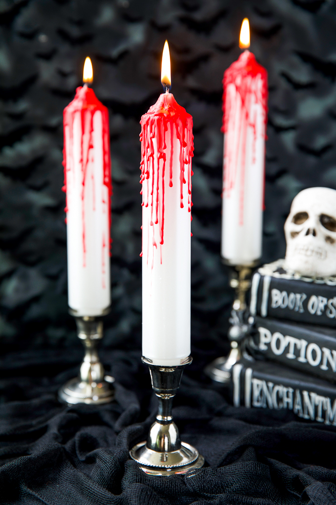 White taper candles with red candle drips - how to make your own bleeding candles for a Halloween table