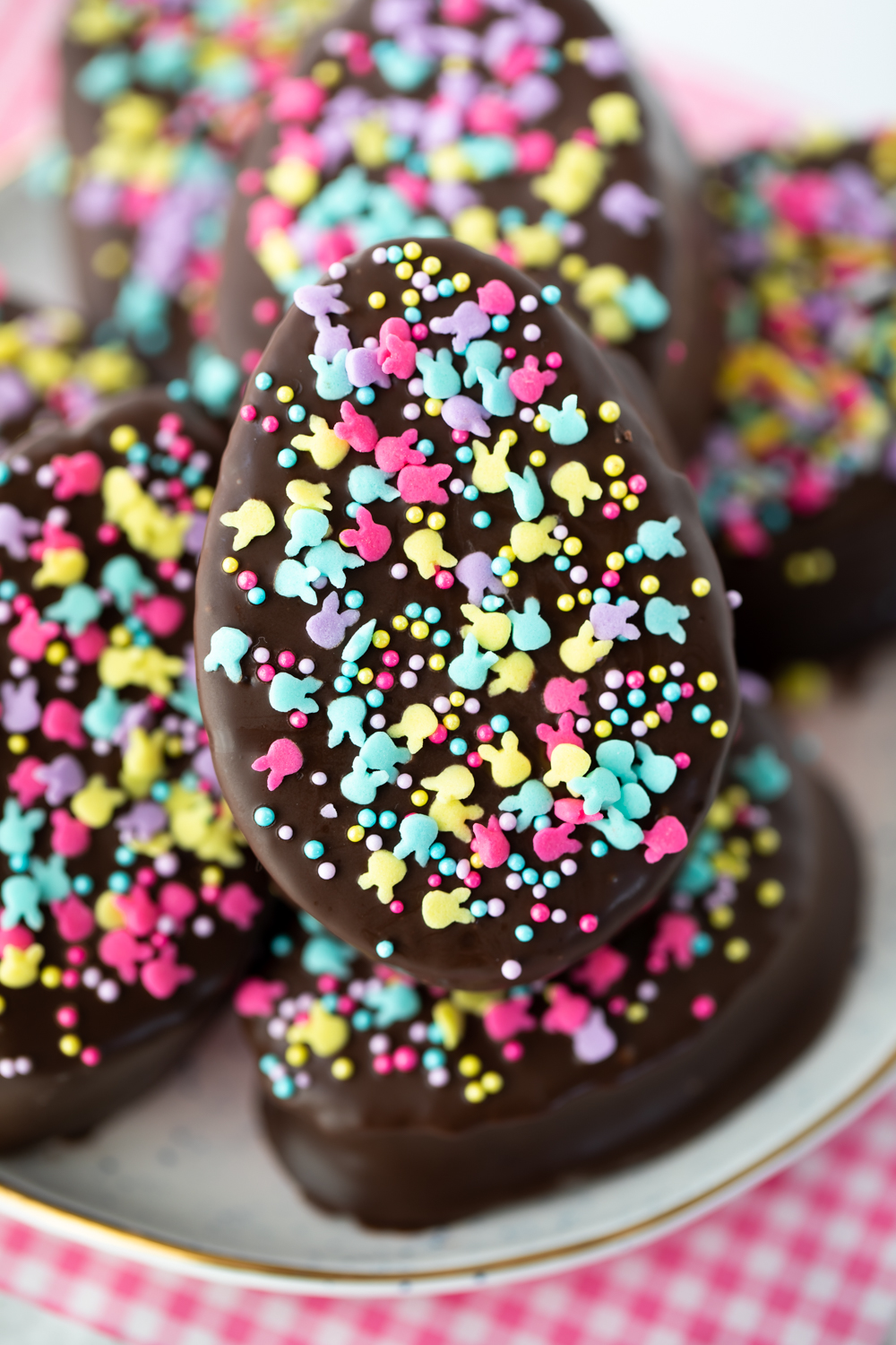 homemade marshmallows cut out in an Easter egg shape dipped in chocolate and decorated with sprinkles