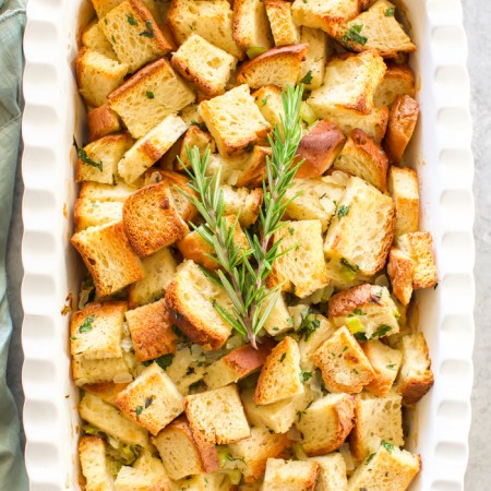 Homemade stuffing recipe made with gluten-free bread cubes, broth, vegetables, and fresh herbs.
