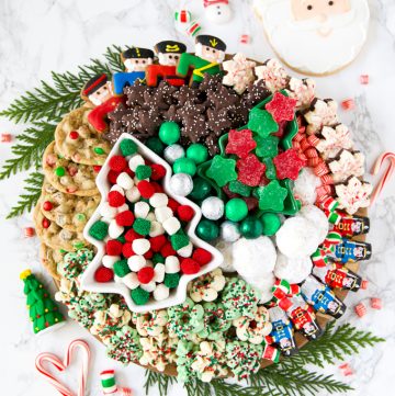 Christmas cookie dessert board with candy and fresh garland decoration