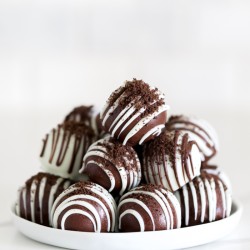 Gluten free Oreo ball recipe dipped in chocolate, with chocolate drizzle, and crushed oreo crumbs