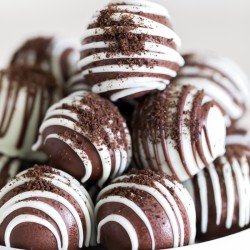 oreo truffles covered in chocolate with chocolate drizzle and oreo crumbs