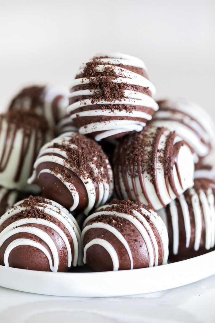 oreo truffles covered in chocolate with chocolate drizzle and oreo crumbs