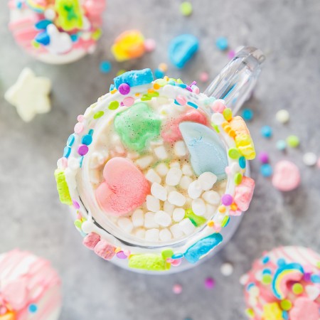 lucky charms marshmallows, white chocolate shell, and rich hot cocoa in a clear mug