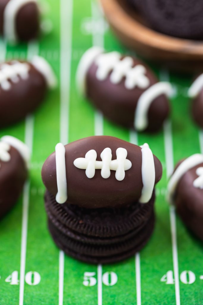 dark chocolate oreo balls shaped into footballs with white chocolate