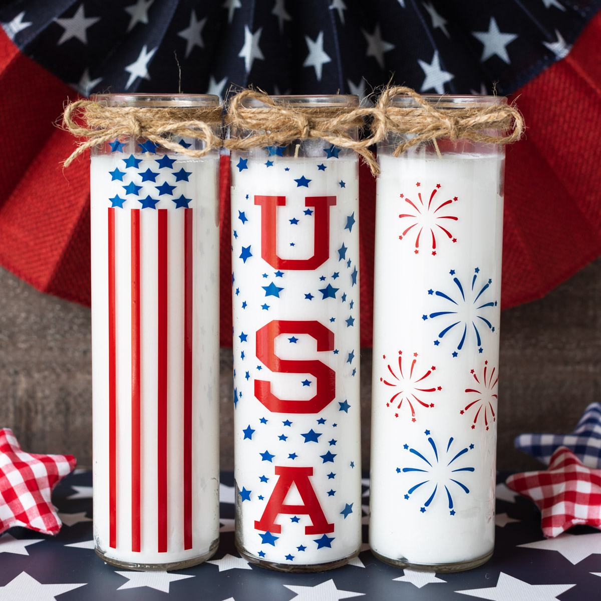 tall white candle jars decorated with red and blue adhesive vinyl in patriotic designs