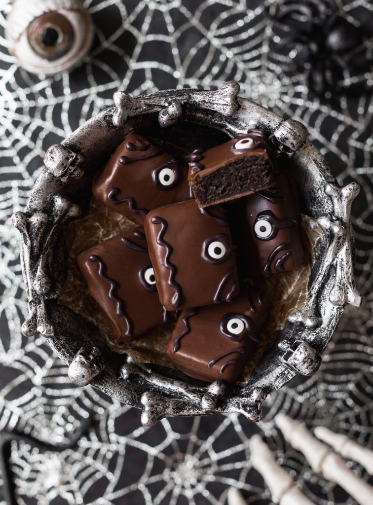 Chocolate-covered book shaped oreo truffles with candy eyes and black icing