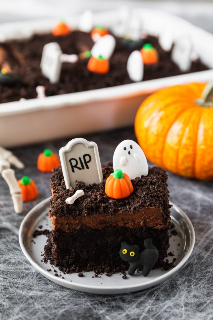 layered chocolate cake with tombstones and Halloween candy
