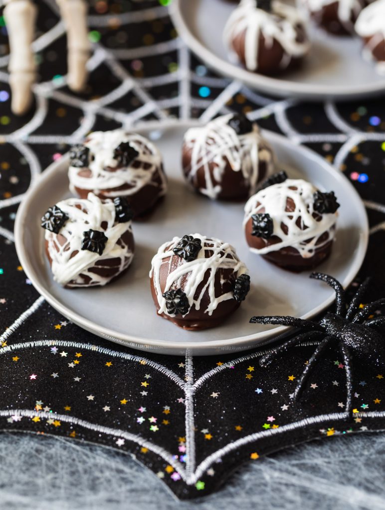 chocolate oreo balls covered in marshmallow spider webs and sprinkles
