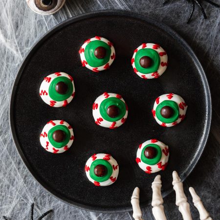 white chocolate covered oreo balls with green eyes and red veins