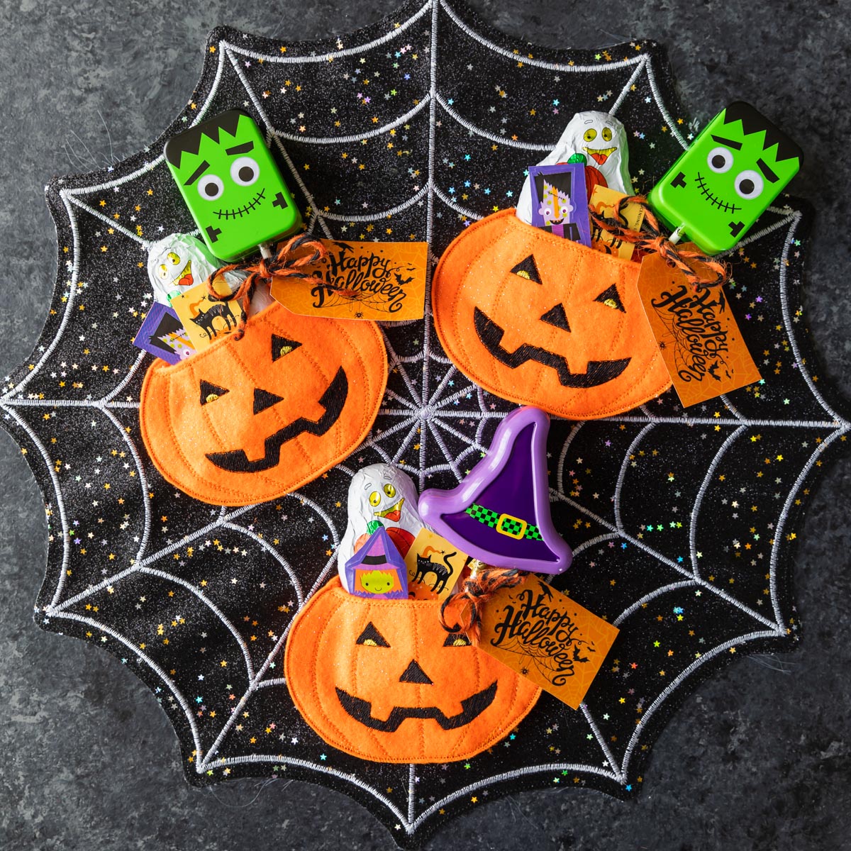 jack-o-lantern felt treat bag filled with Halloween candy