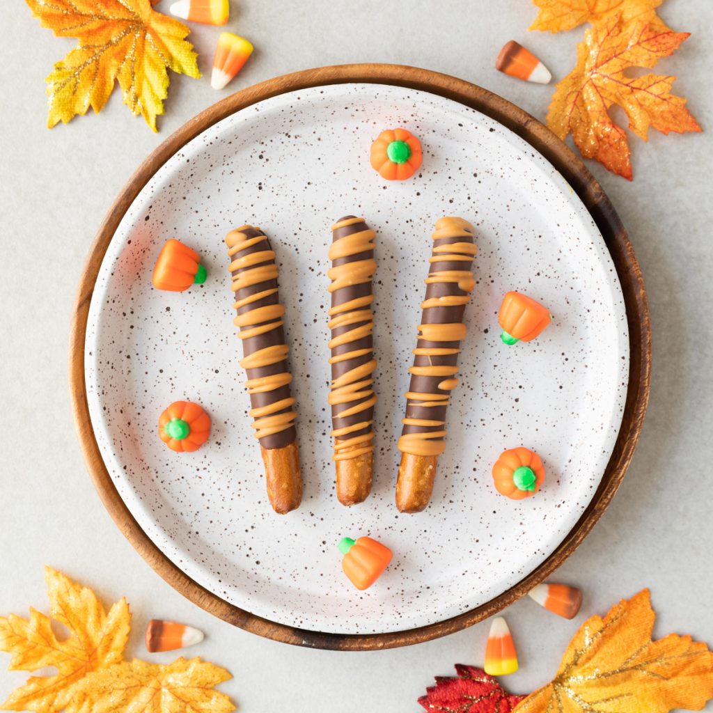 chocolate dipped pretzels with pumpkin spice drizzled on top