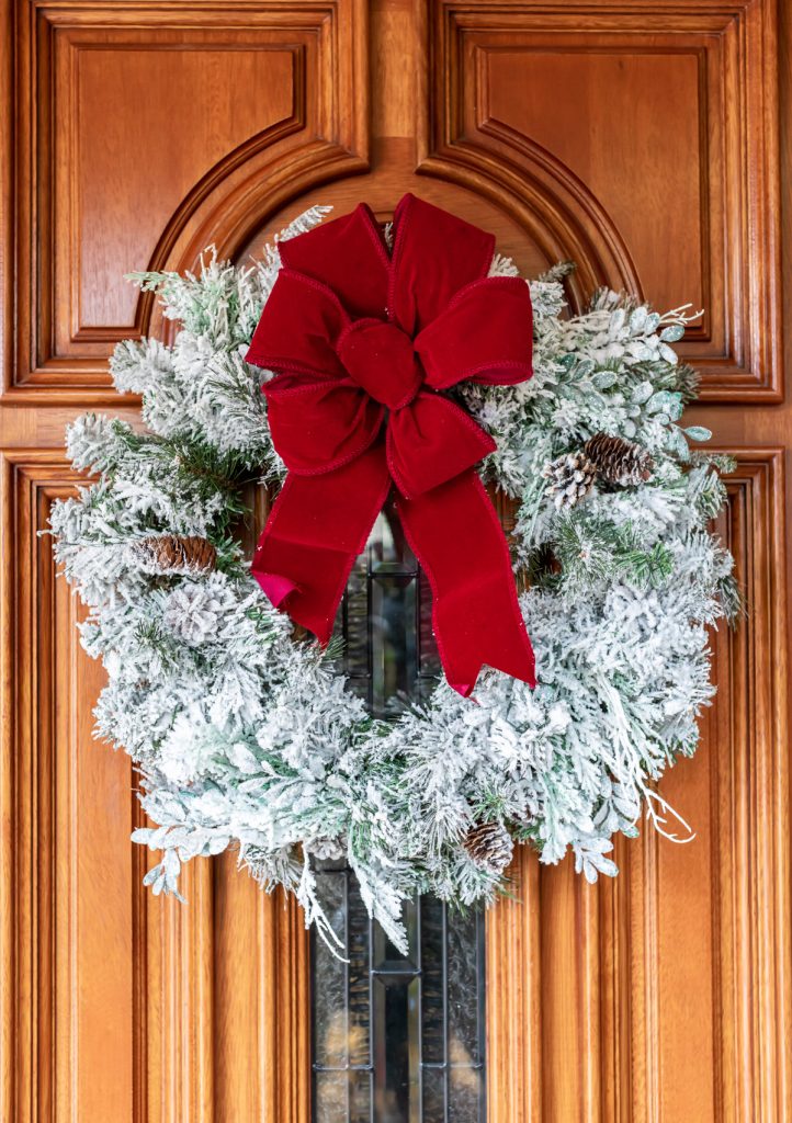 snowy flocked wreath decorated with a red bow