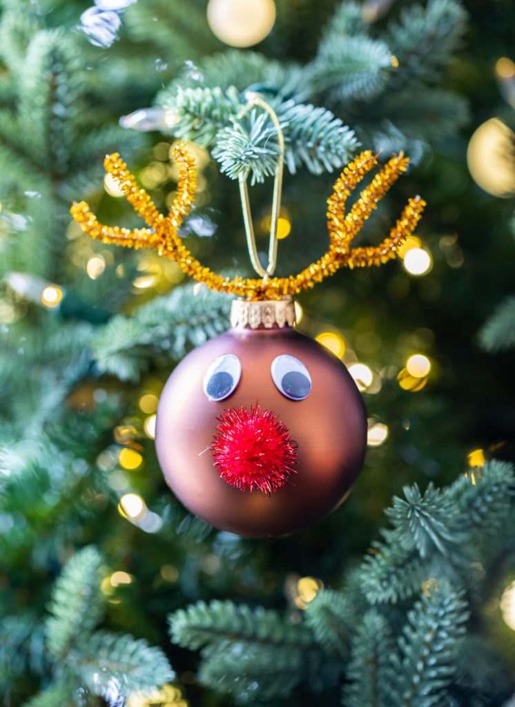 brown ornament ball decorated with red pom pom and pipe cleaner antlers