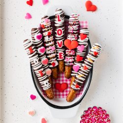 easy chocolate dipped pretzels with red, pink, and heart shaped sprinkles