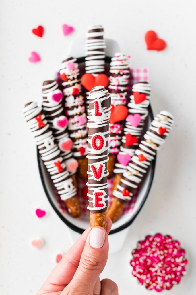 chocolate pretzel rods with LOVE icing decorations