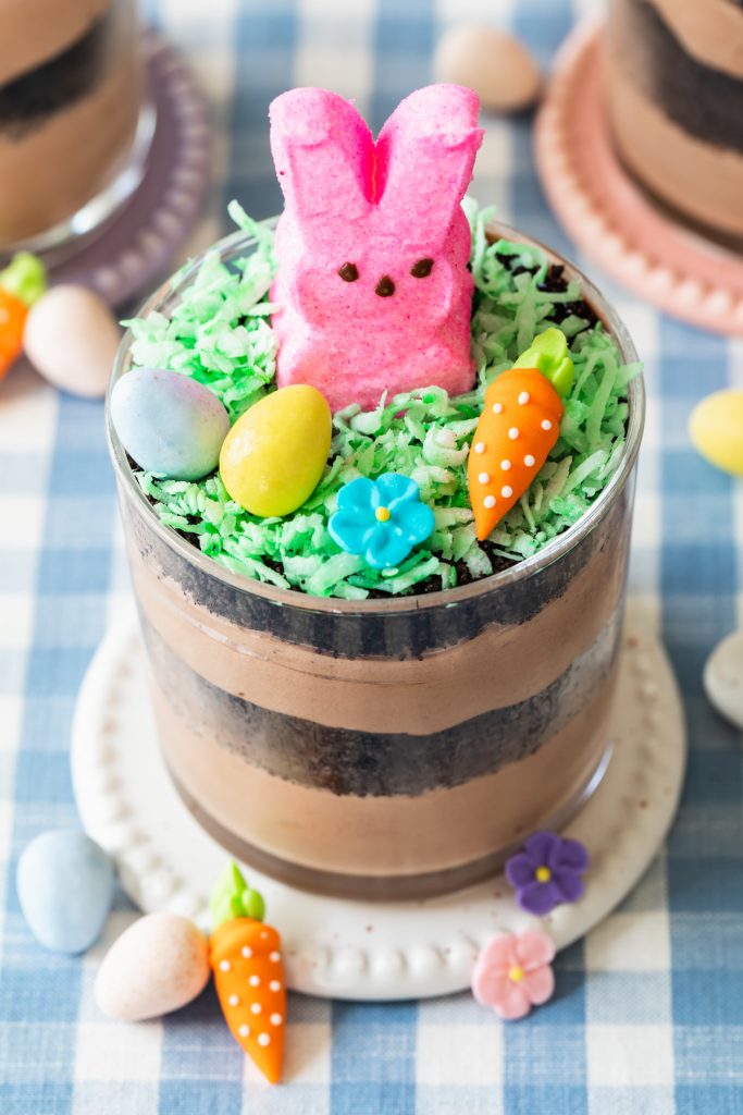 Easter dirt cups with marshmallow Peeps bunny, green coconut shreds, and mini eggs
